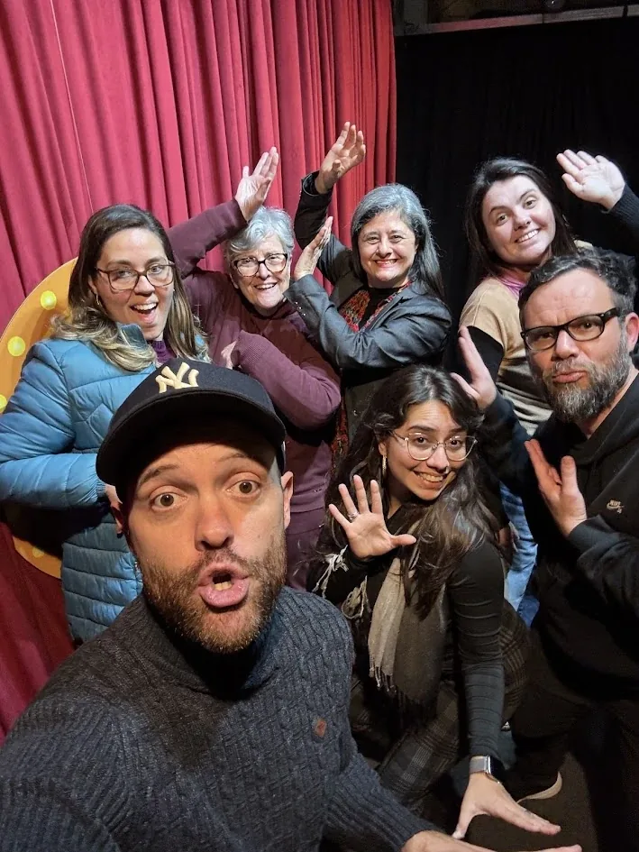 Turma do Nível 2 fazendo pose no palco de cortina vermelha