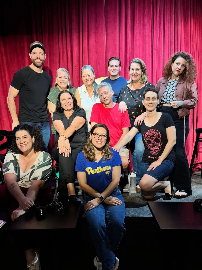 Turma reunida no palco de cortina vermelha